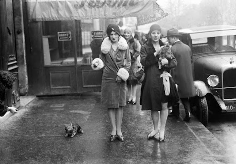 Young women walking their cat in November 1929 in Paris, France. 