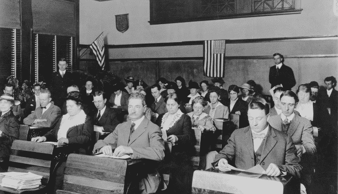 Classroom of immigrants learning English and US political culture in 1920.