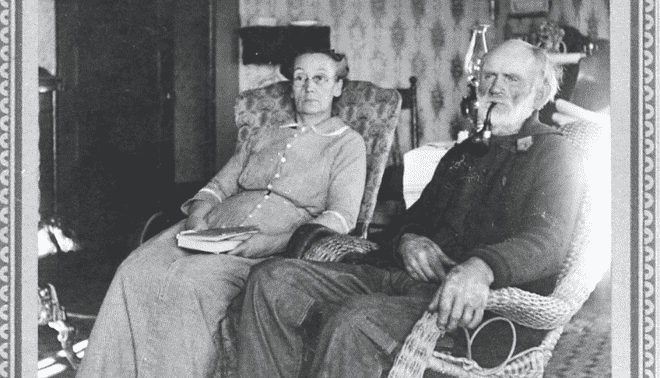 Black and white photo of an elderly couple in rocking chairs.