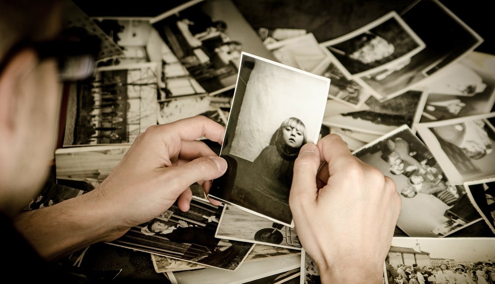 Man holding black and white photos.