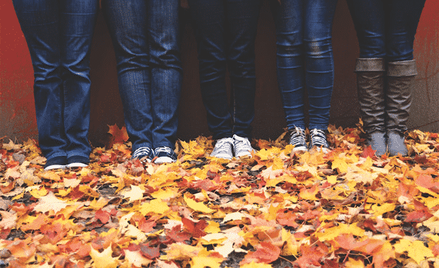 People standing in fall leaves.