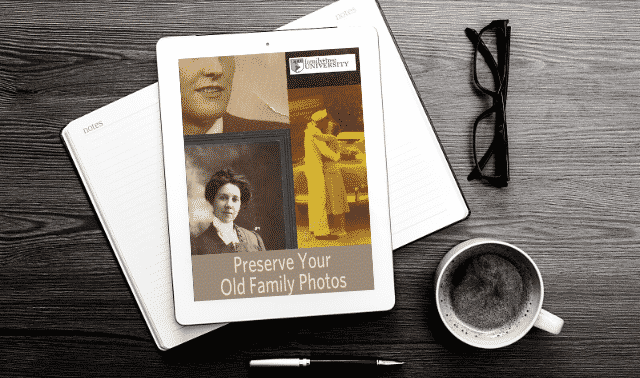 An iPad laying on top of an open book, showing the Preserve Your Family Photos ebook.